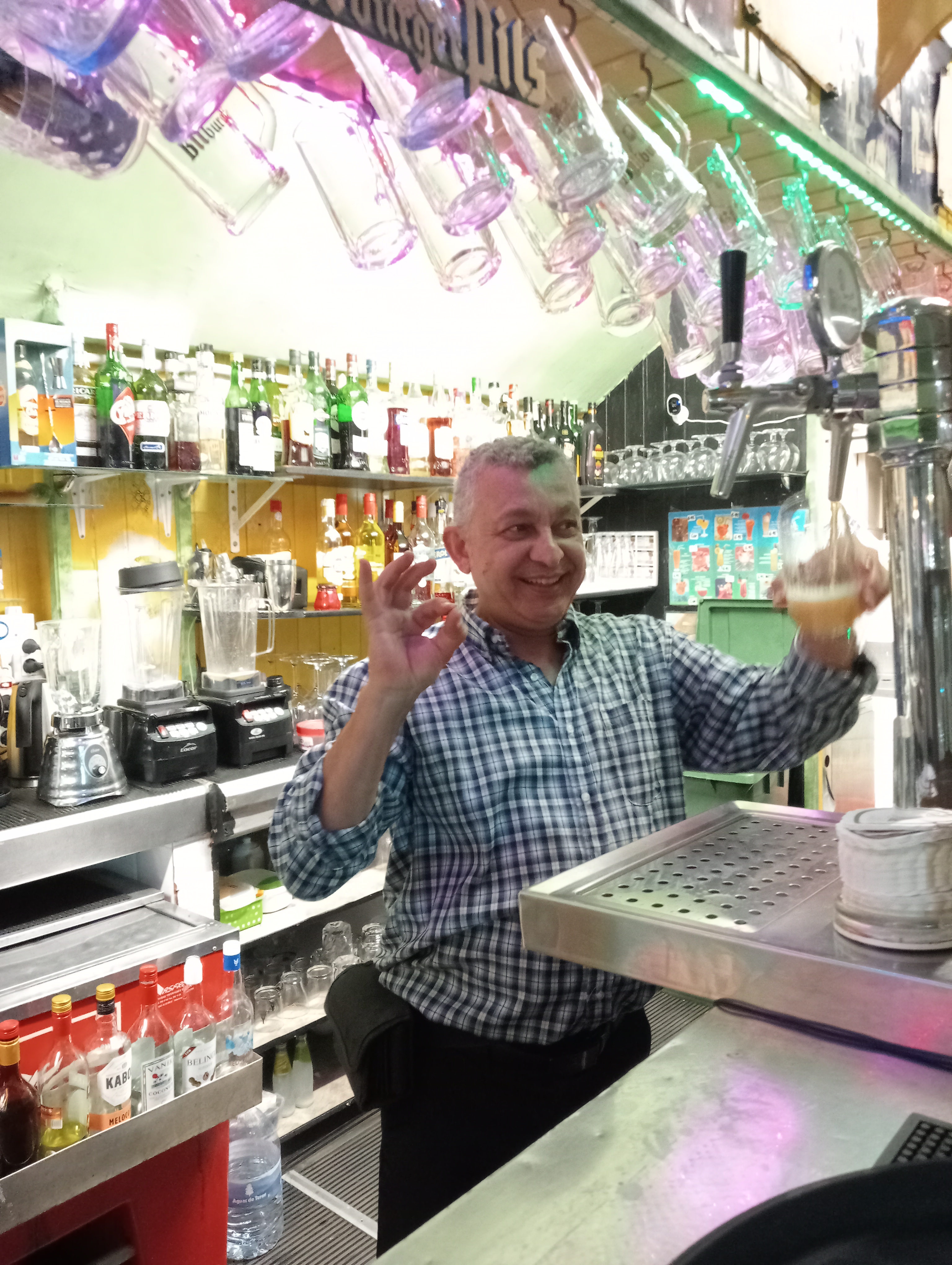 Unser Chef Manolo im Café Marlene hinter der Theke beim Bier zapfen